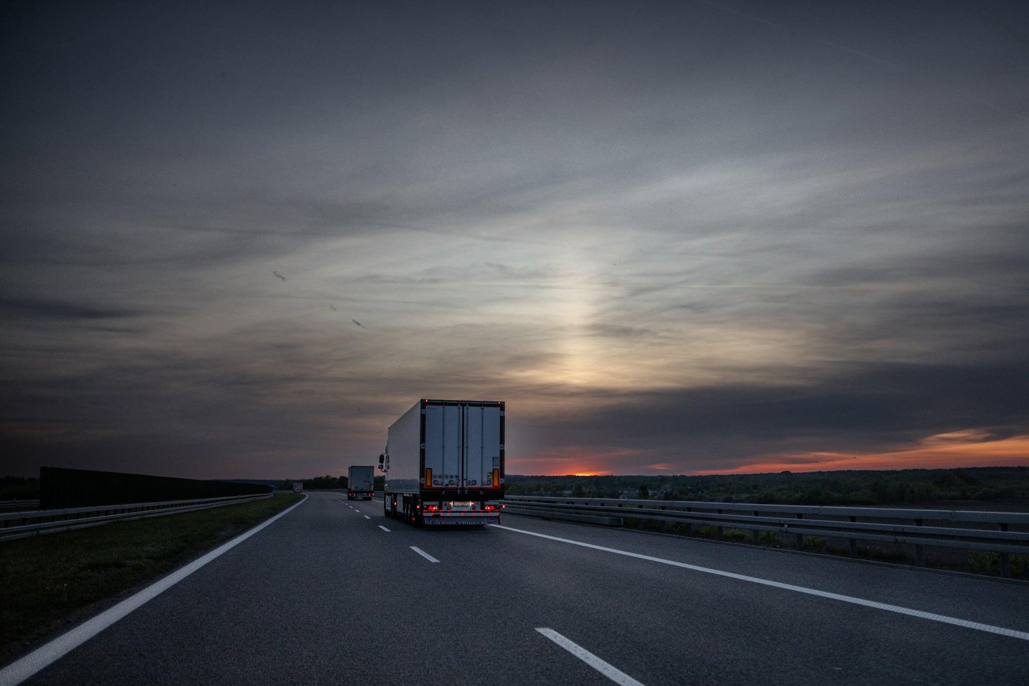 Articulated cargo truck on a highway at sunrise